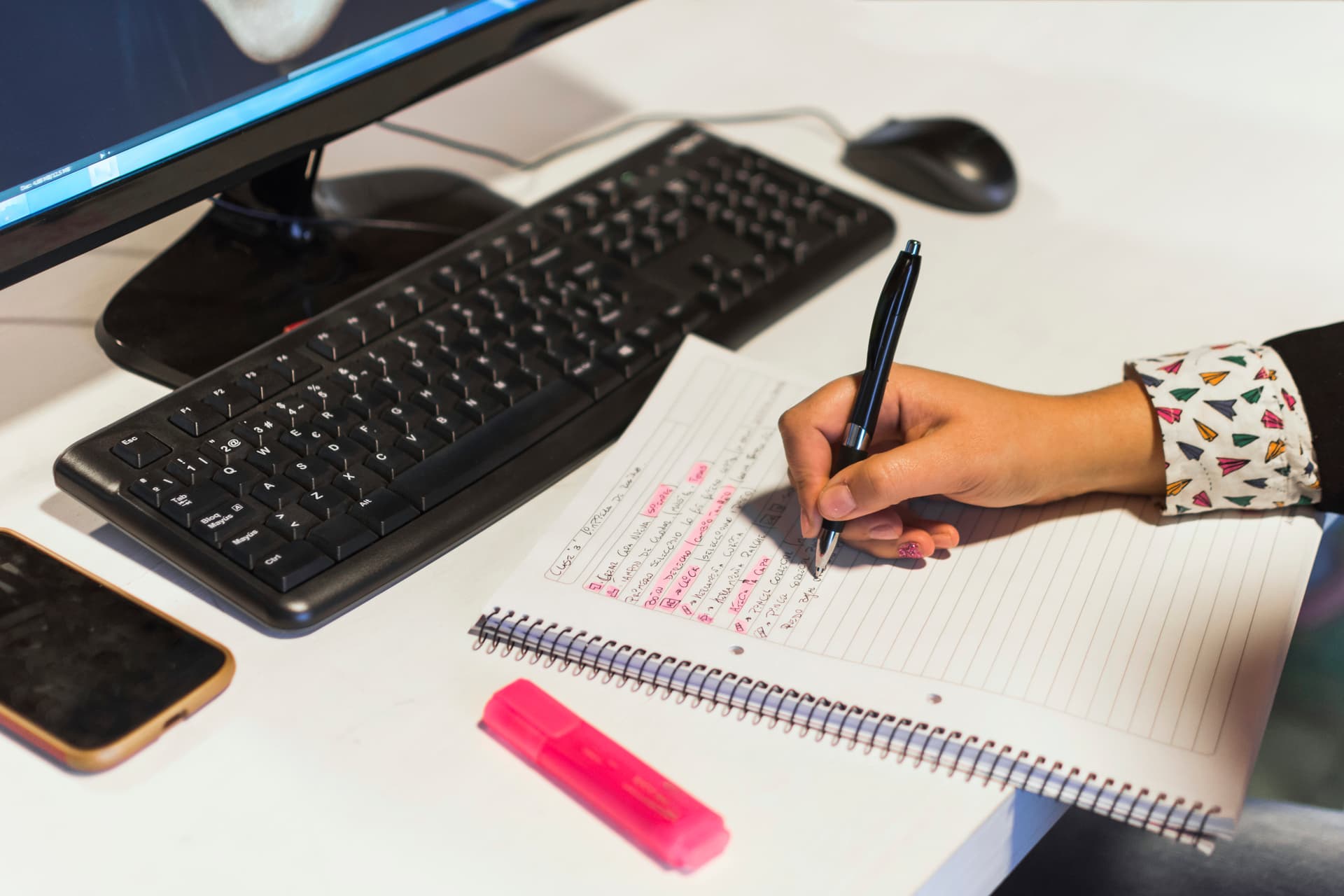 Person editing document with keyboard and notebook